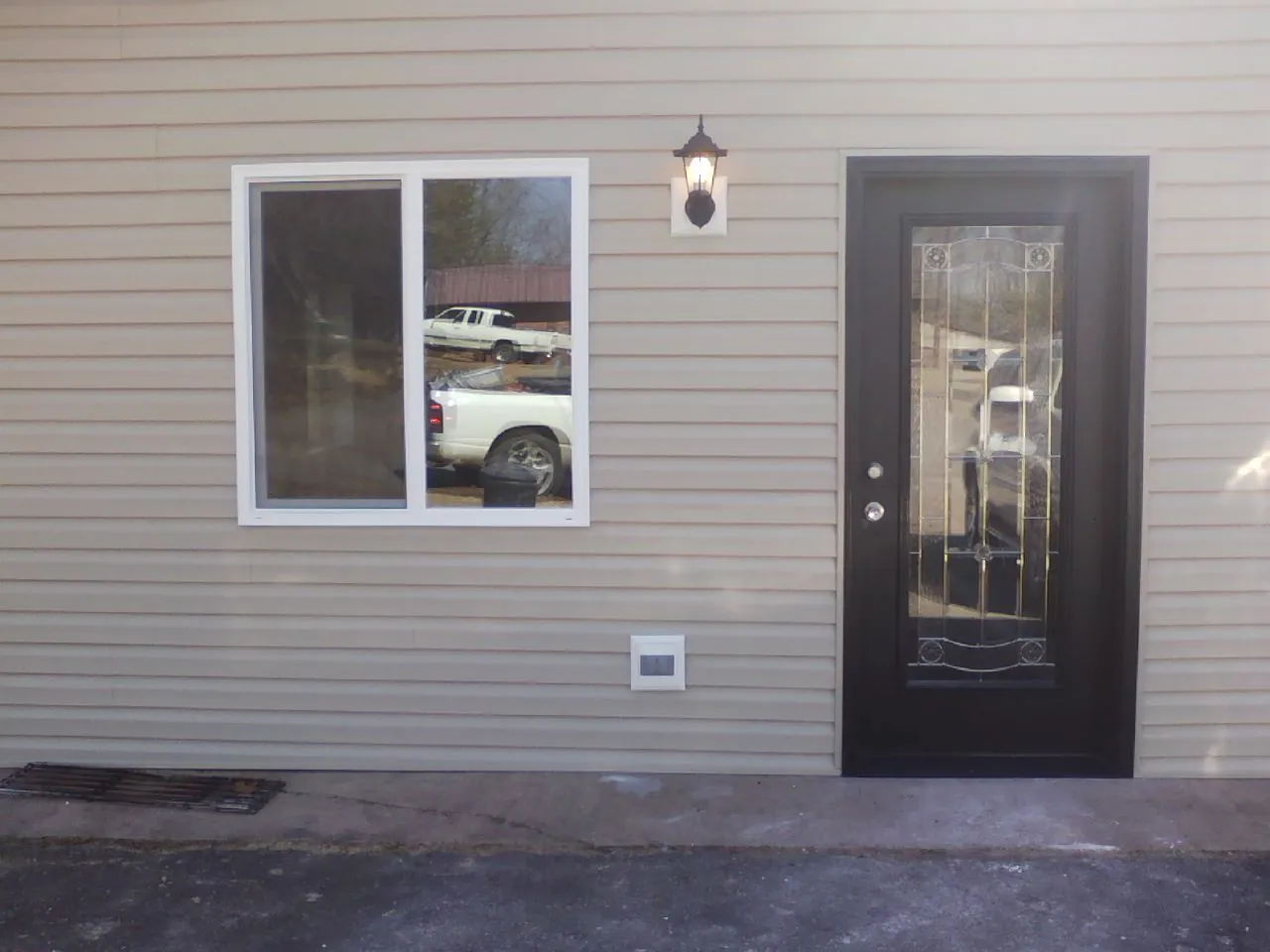 New siding, window and entry door on the side of an addition in Carthage